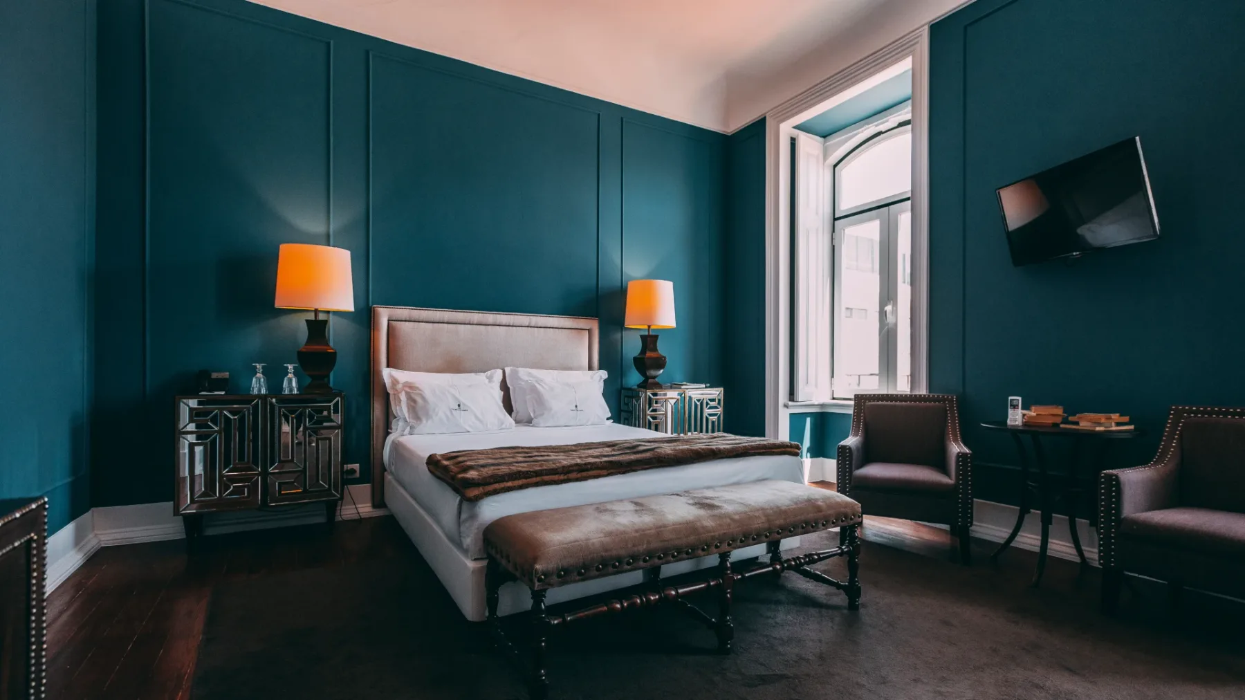 Dormitorio elegante con paredes de color verde azulado y muebles con estilo