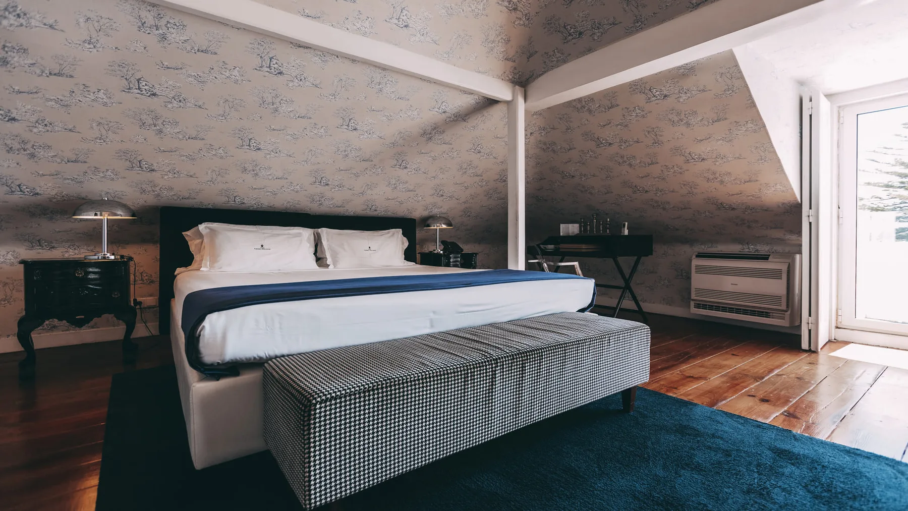 Dormitorio con una pared estampada y una ventana