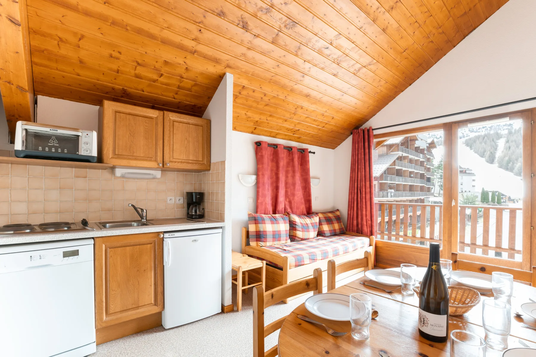 A compact kitchen opens onto a dining and seating area beside the balcony.