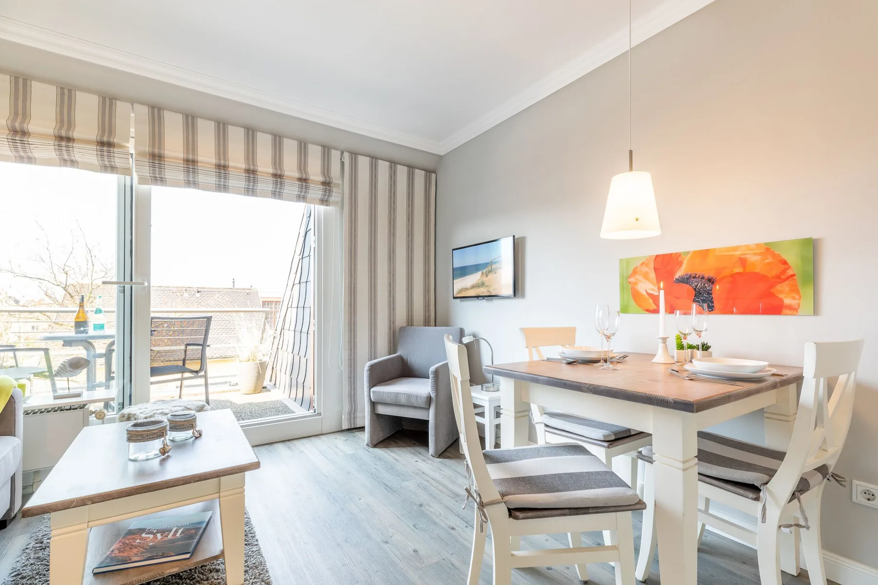 A bright dining area with a table beside large windows and a balcony.