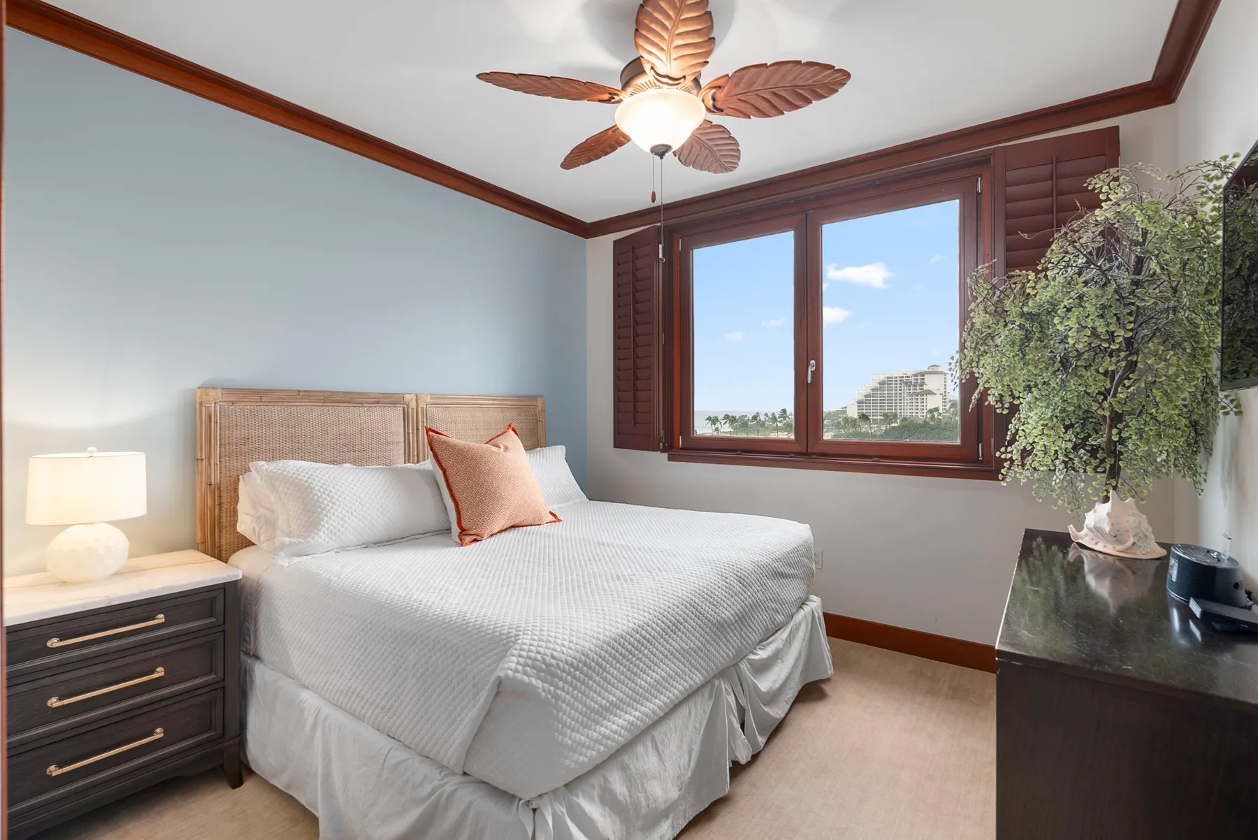 Un dormitorio con una cama tendida junto a una ventana.