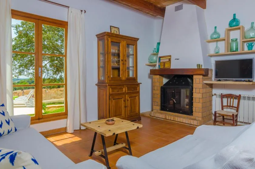 A living room with a brick fireplace, wooden cabinet, and seating.