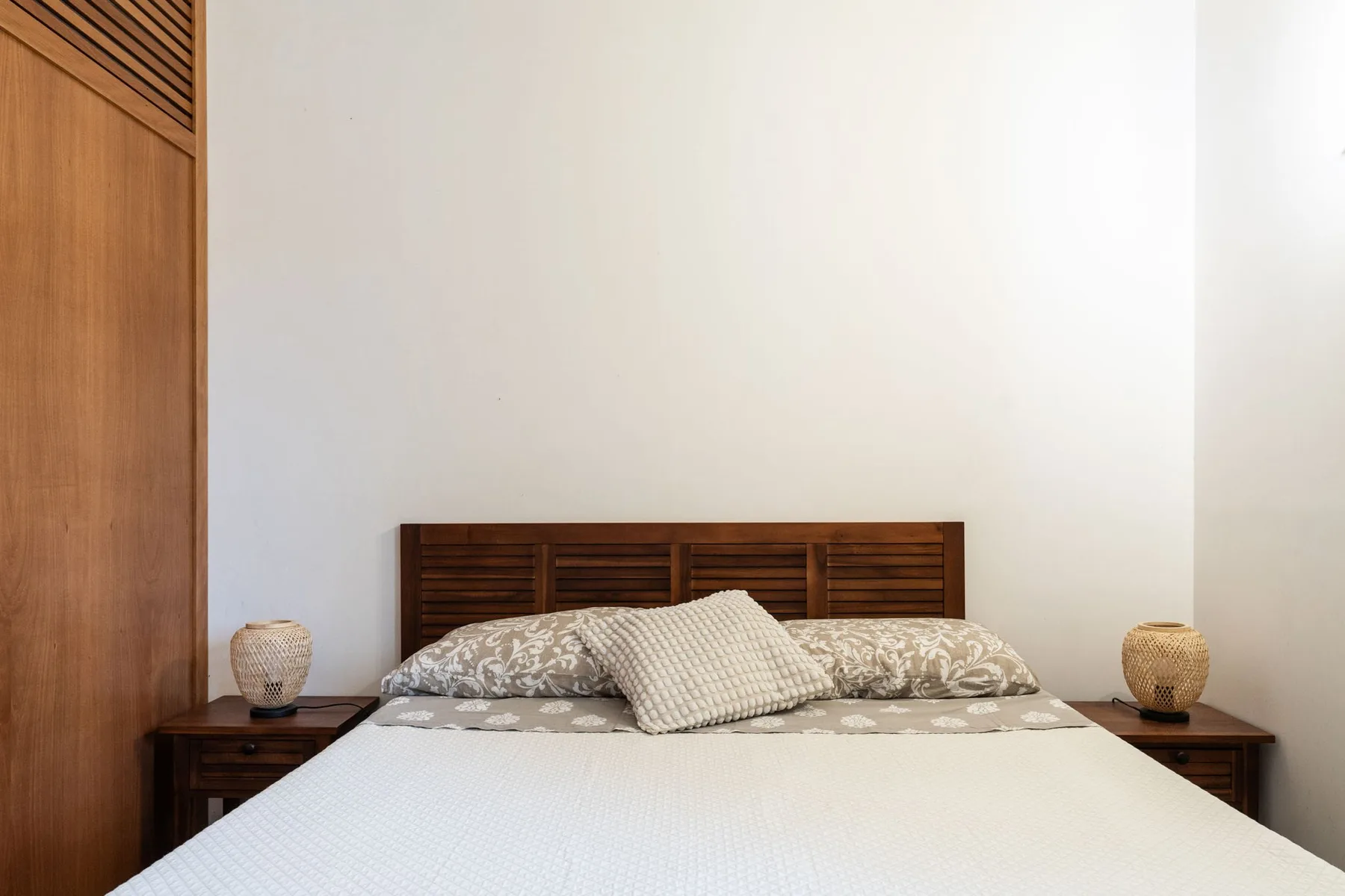 Un dormitorio con una cama tendida y un cabecero de madera.