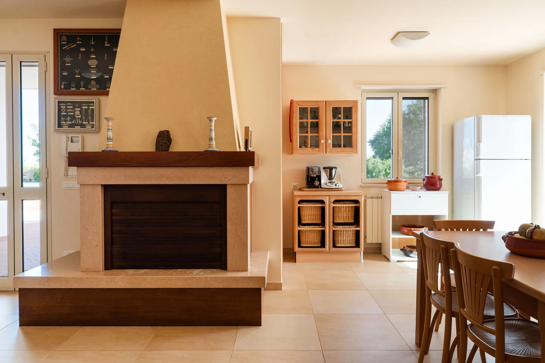 Una luminosa sala-comedor de espacio abierto con chimenea y ventanas grandes.
