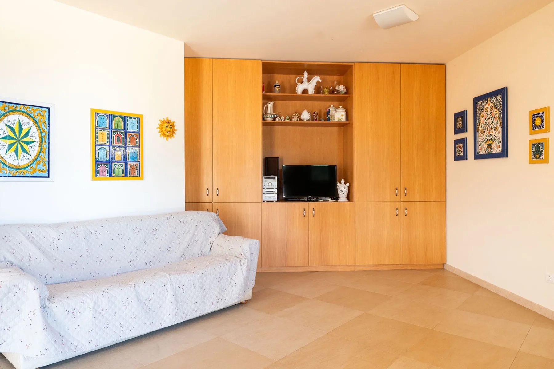 Una sala de estar con asientos, un televisor y armarios empotrados de madera.