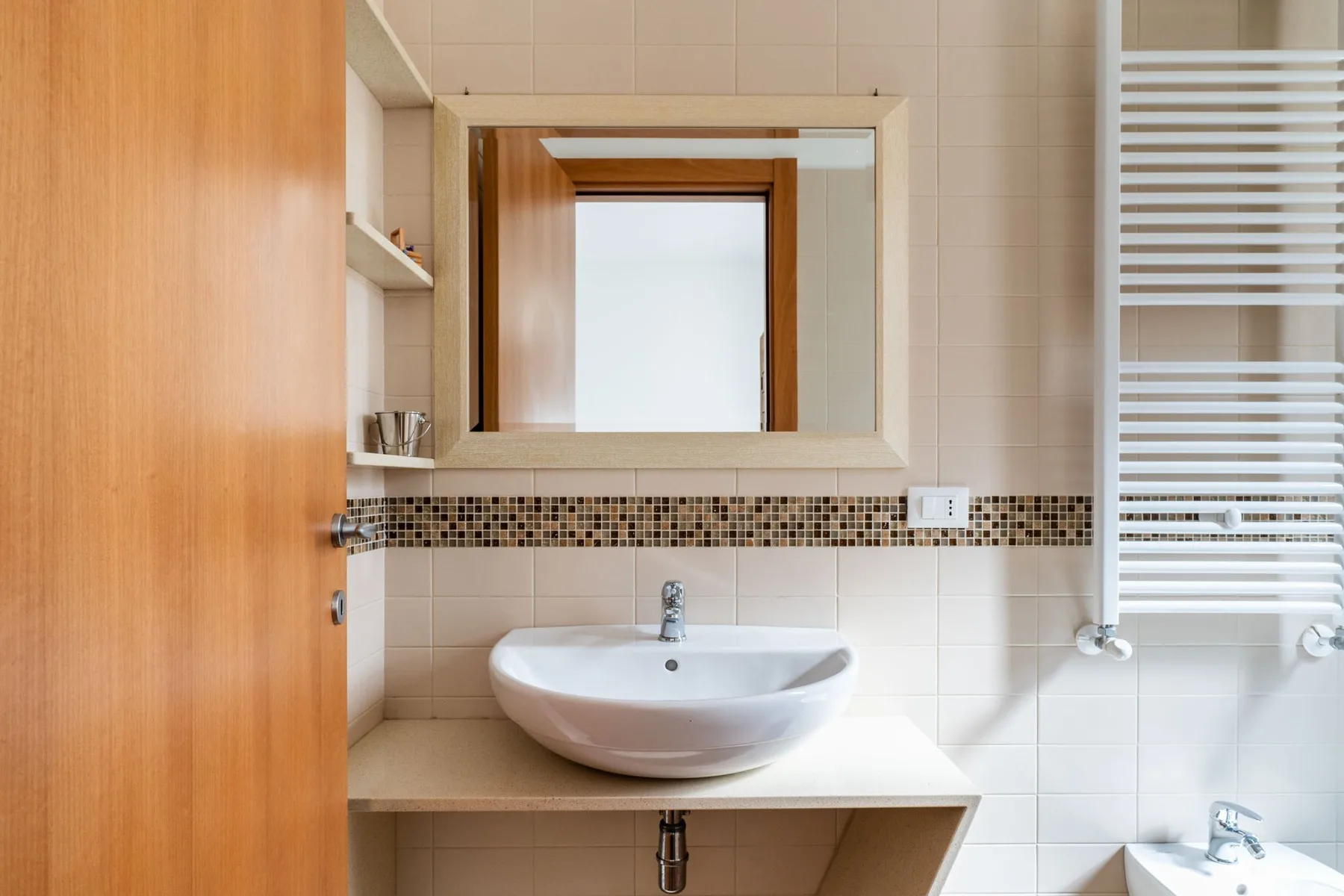 Un lavabo de baño con un fregadero blanco y un espejo.