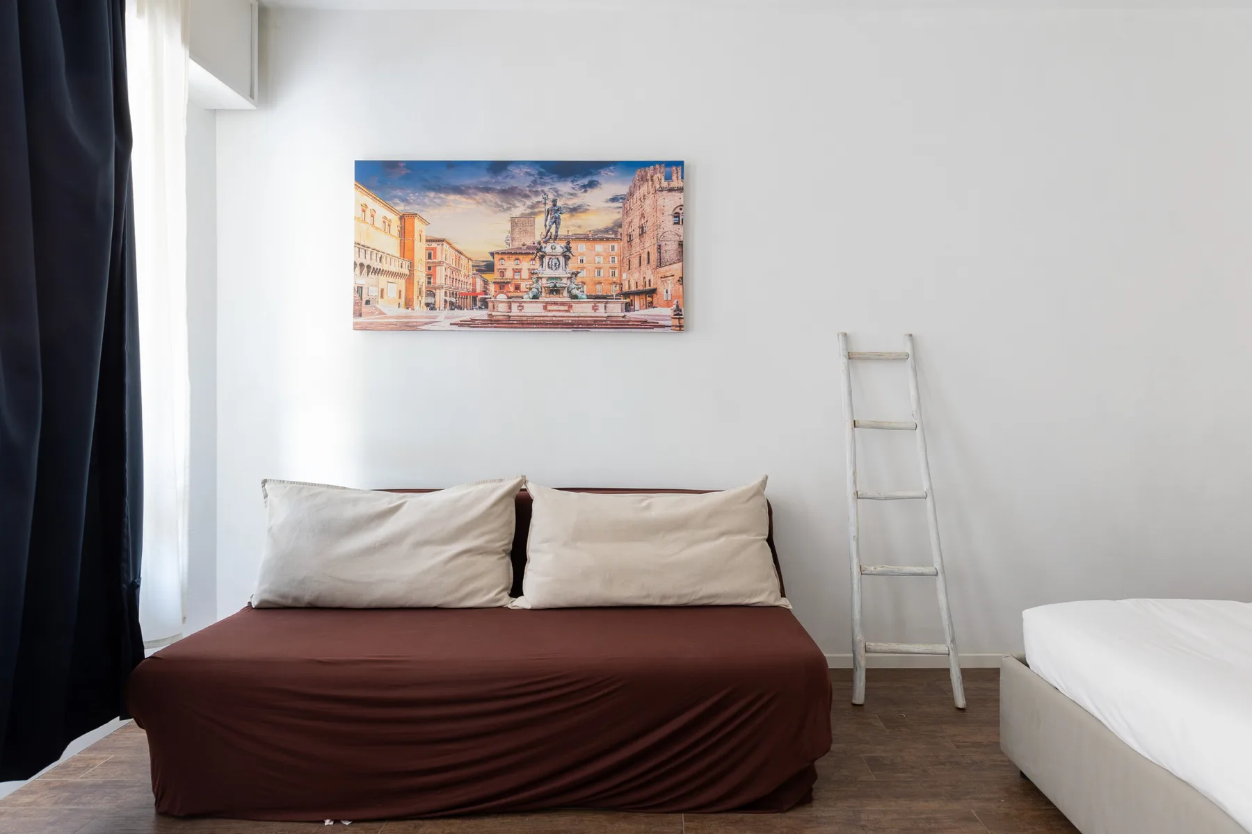 Un dormitorio con una cama bajo una colorida pintura urbana.