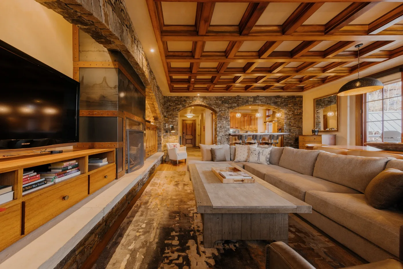 A spacious living room with seating, a low table, and a television.