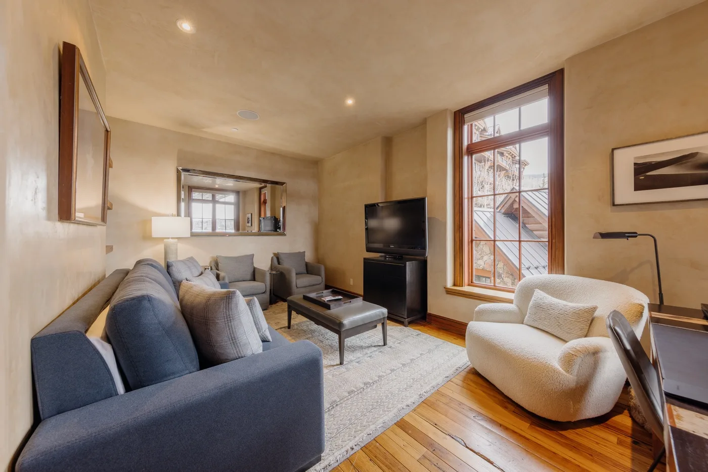 A living room with seating arranged around a coffee table and television.