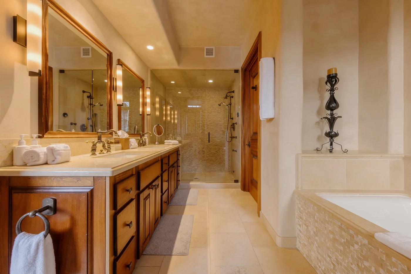 A spacious bathroom with a long vanity and a walk-in shower.