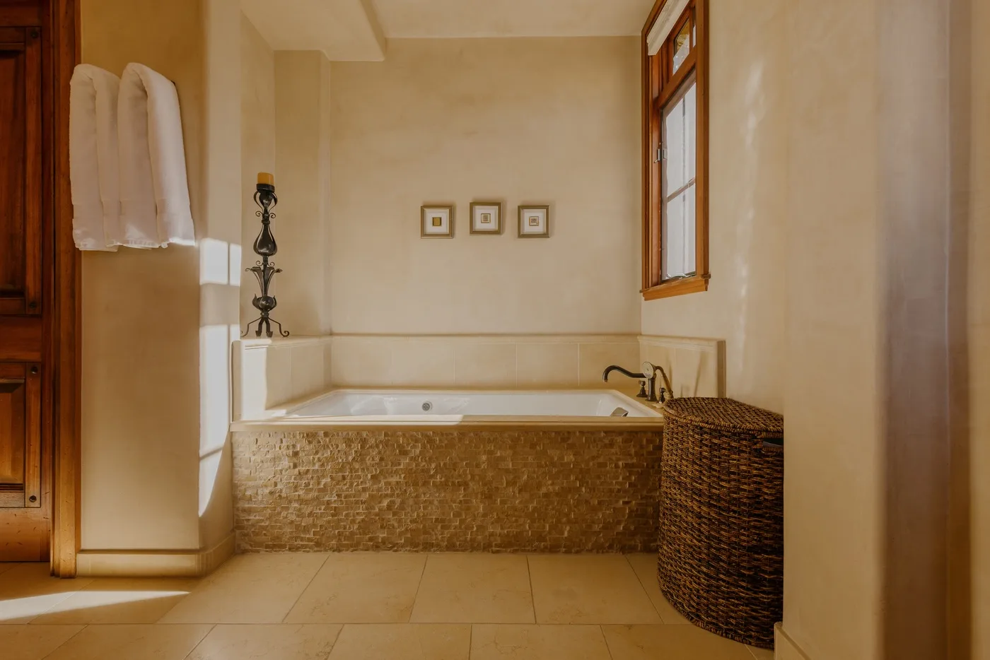 A bathroom features a built-in bathtub beside a woven basket.
