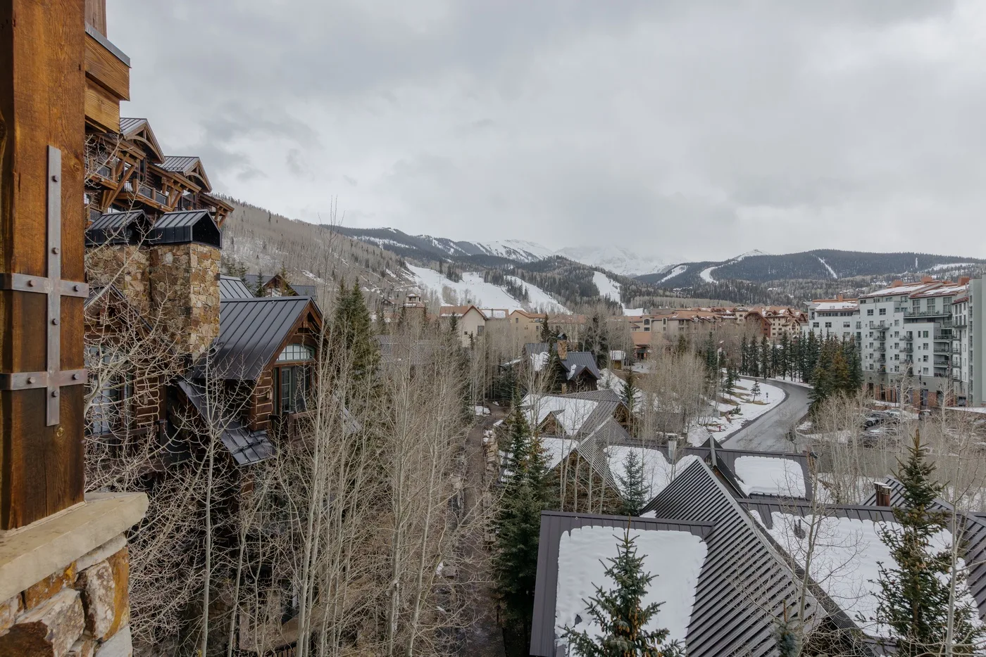 A snowy mountain resort village with clustered buildings and wooded slopes.