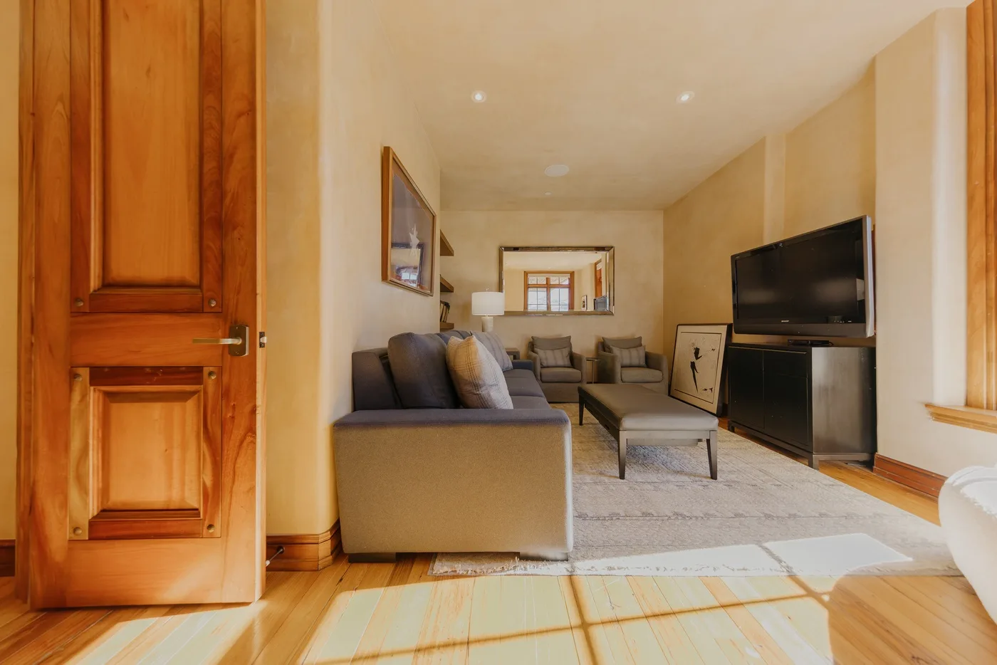 A living room with seating arranged around a coffee table and television.