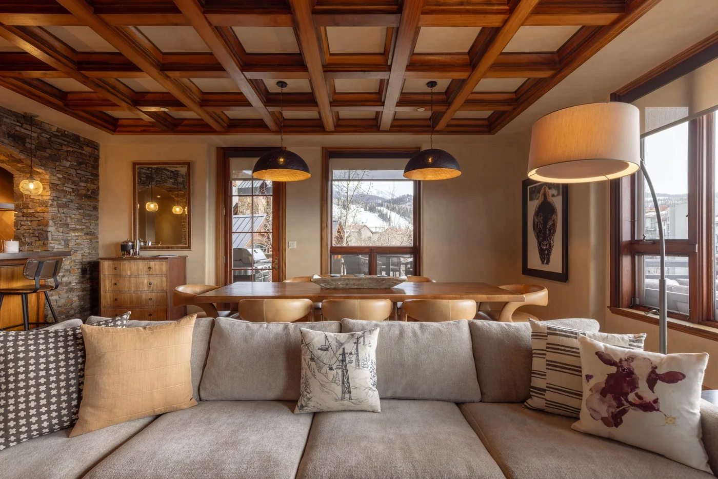 A living room with a large sectional seating area and a wood-beamed ceiling.