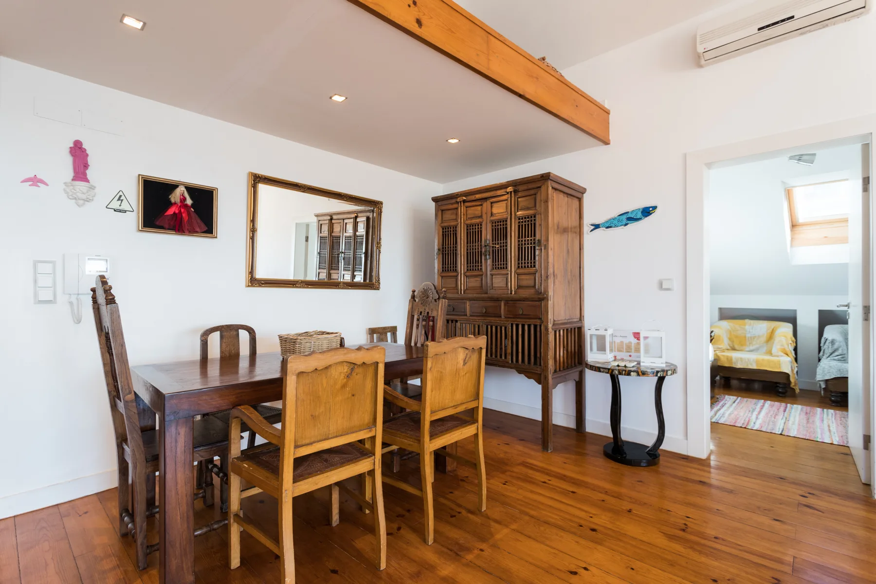 Comedor con una mesa de madera y sillas junto a un armario alto.