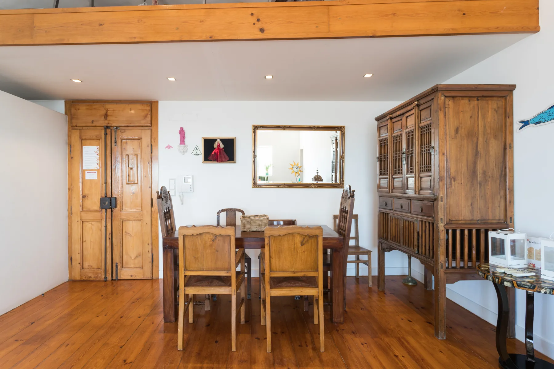 Un comedor con asientos de madera y un armario grande junto a la pared.