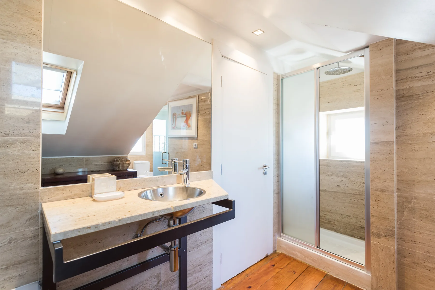 Un baño con lavabo y una ducha de cristal.