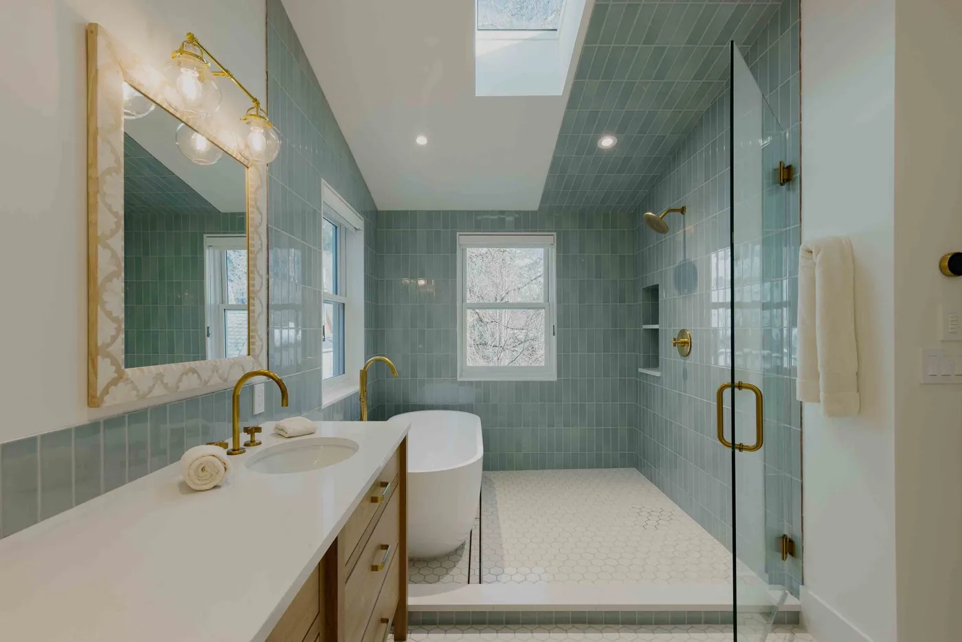 Un baño con un tocador largo, una bañera exenta y una ducha de vidrio.