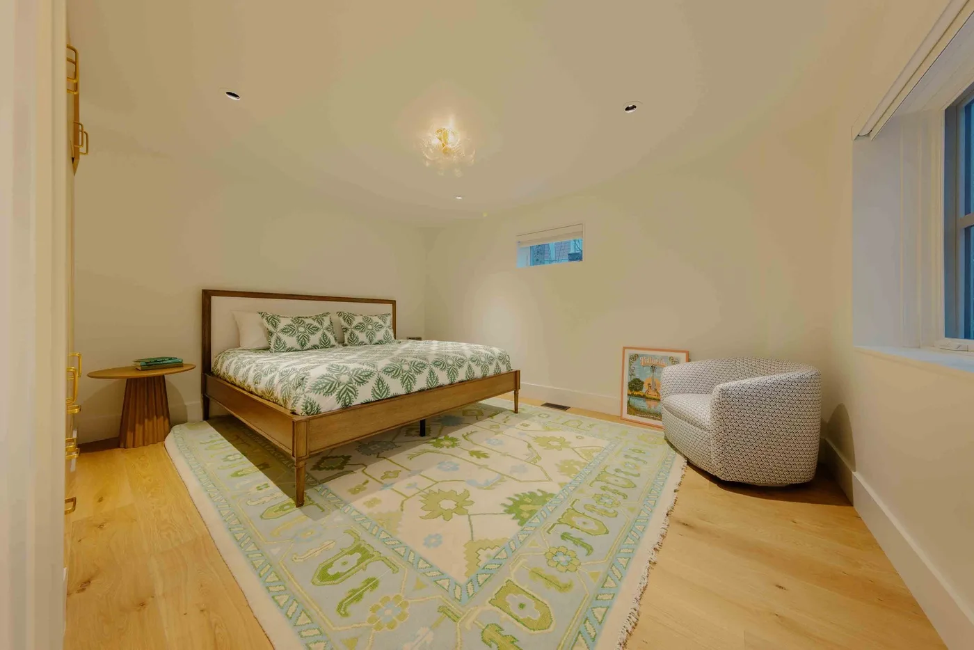 Un dormitorio con una cama de madera, ropa de cama estampada y una alfombra grande.