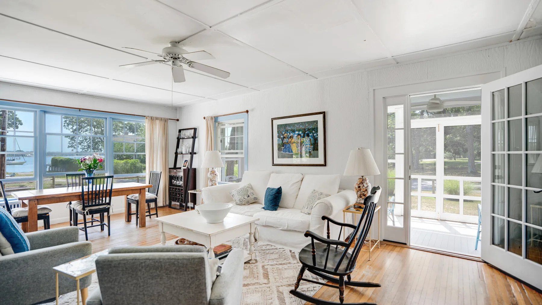 A bright living room with seating beside large windows and glass doors.
