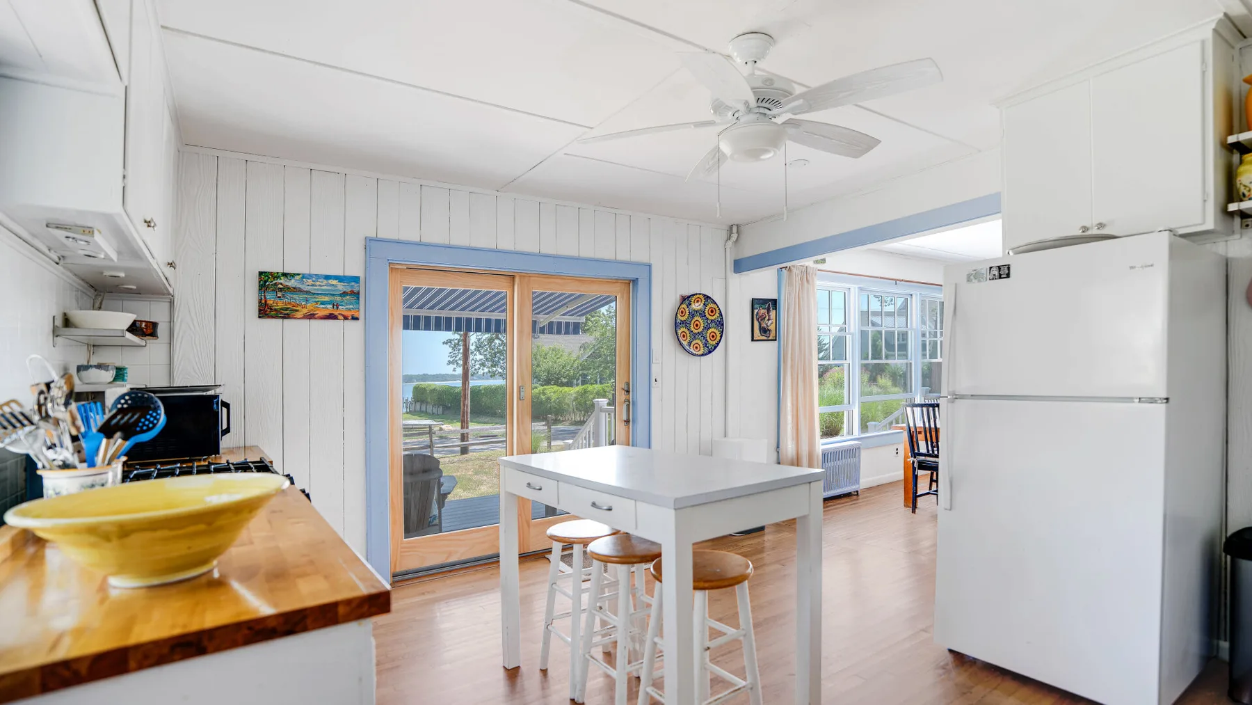 A bright kitchen with a white island and glass doors opening to a patio.