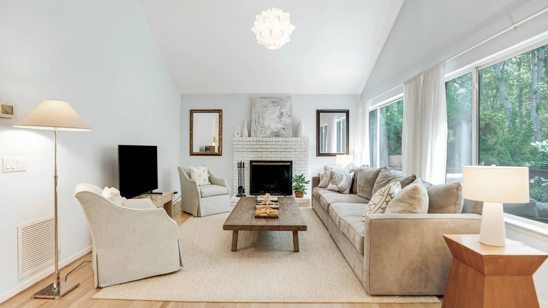 A bright living room with seating arranged around a coffee table and fireplace.