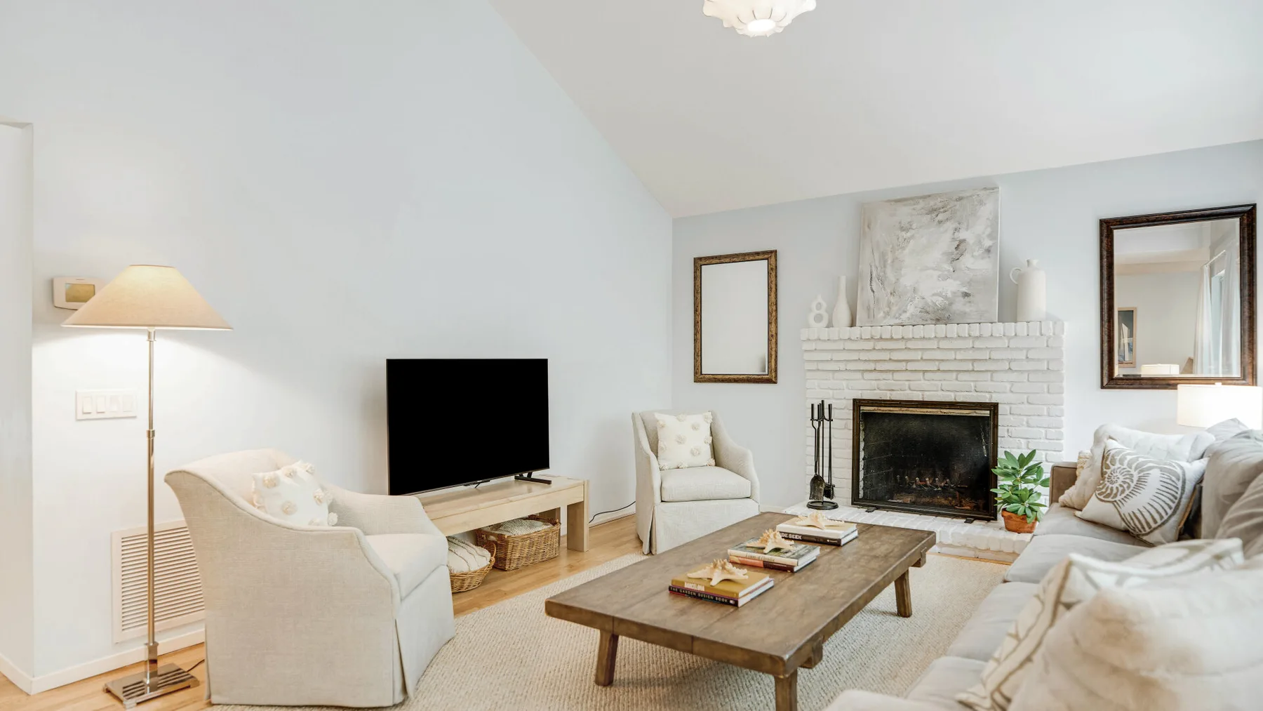 Una sala luminosa con asientos alrededor de una mesa de centro y una chimenea.
