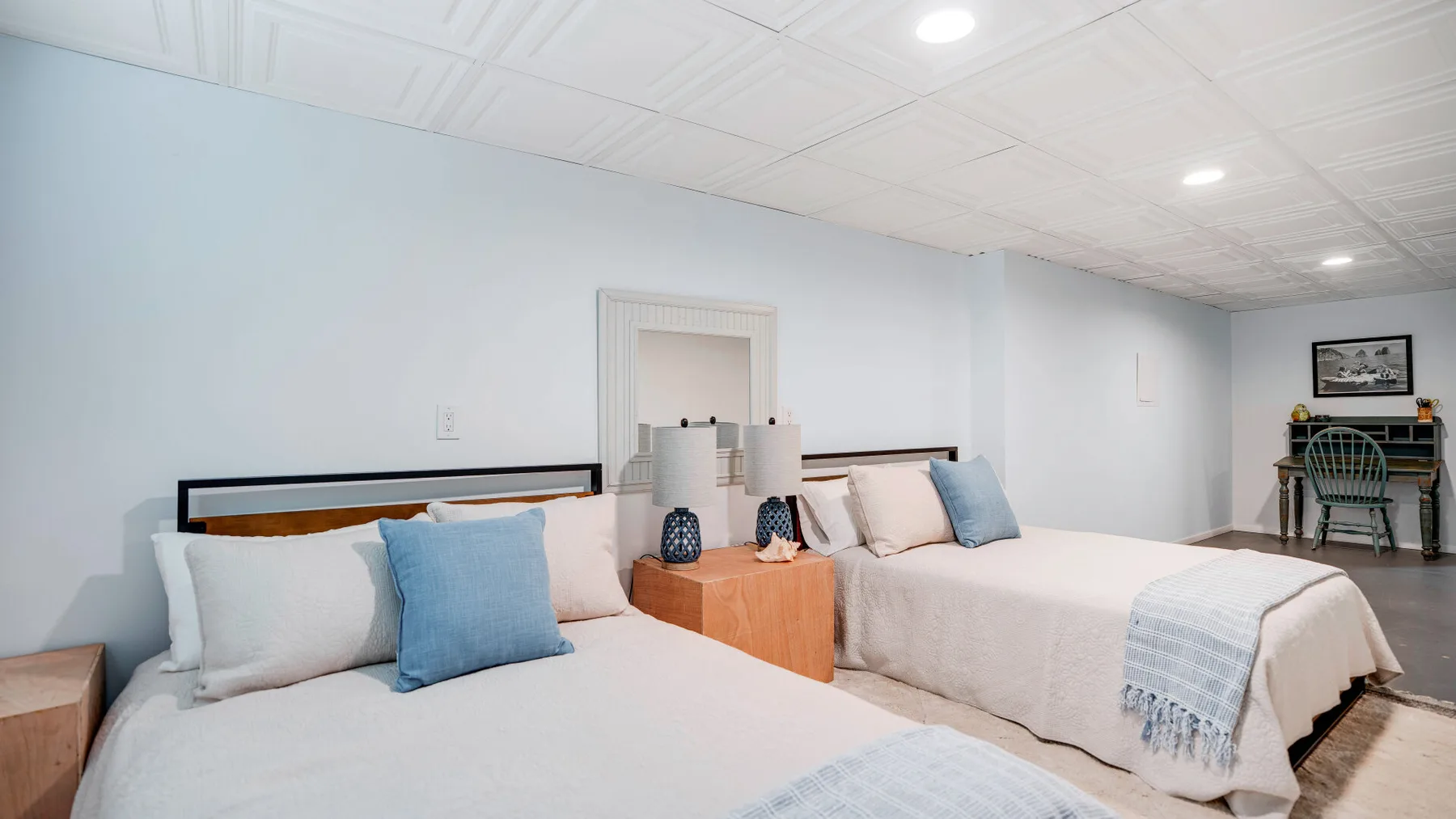 Un dormitorio con dos camas y ropa de cama de tonos claros.