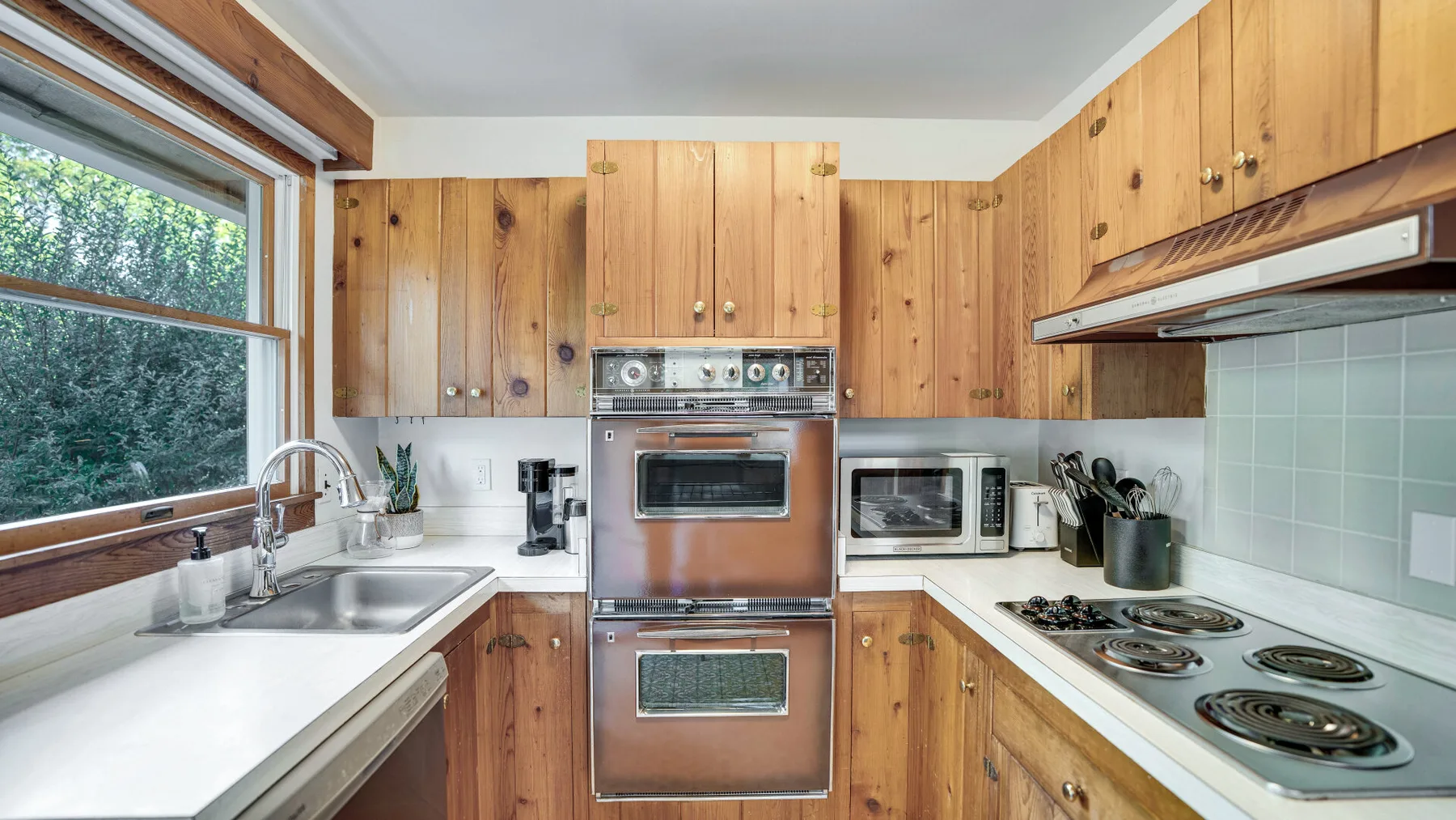 A wood-cabinet kitchen with a large double oven and a long counter.