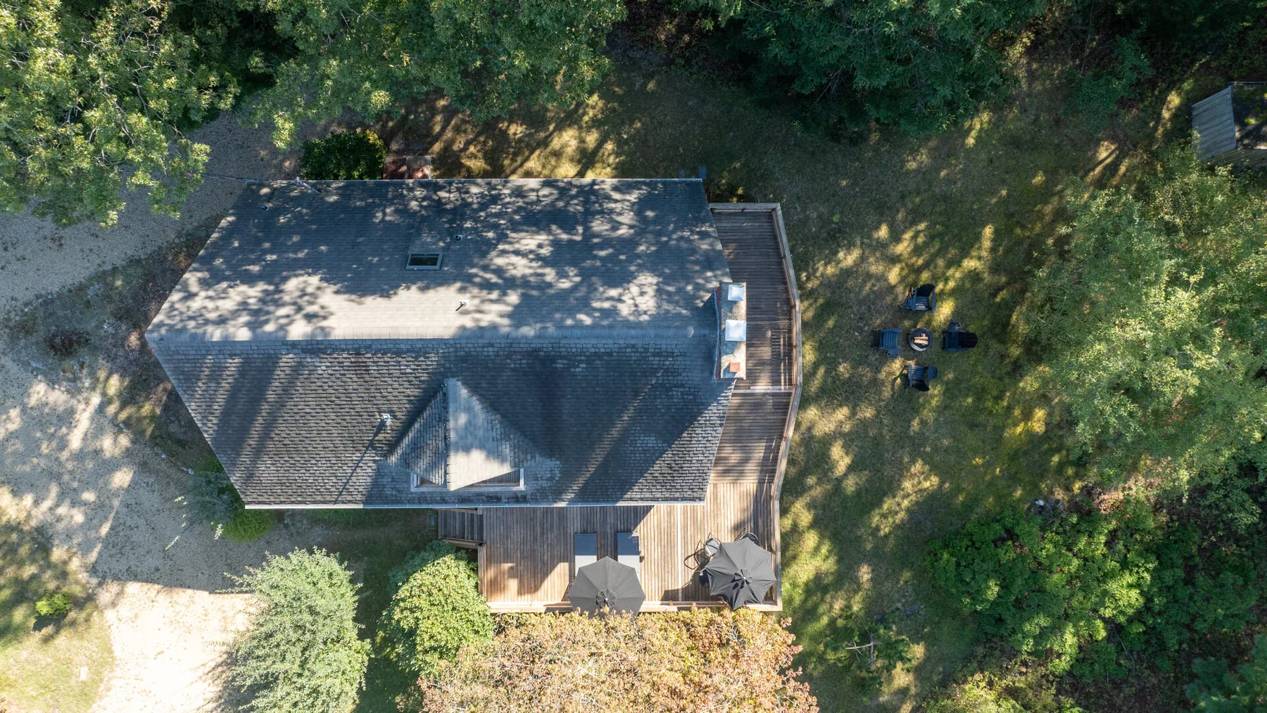 Aerial view of a house surrounded by trees and greenery.