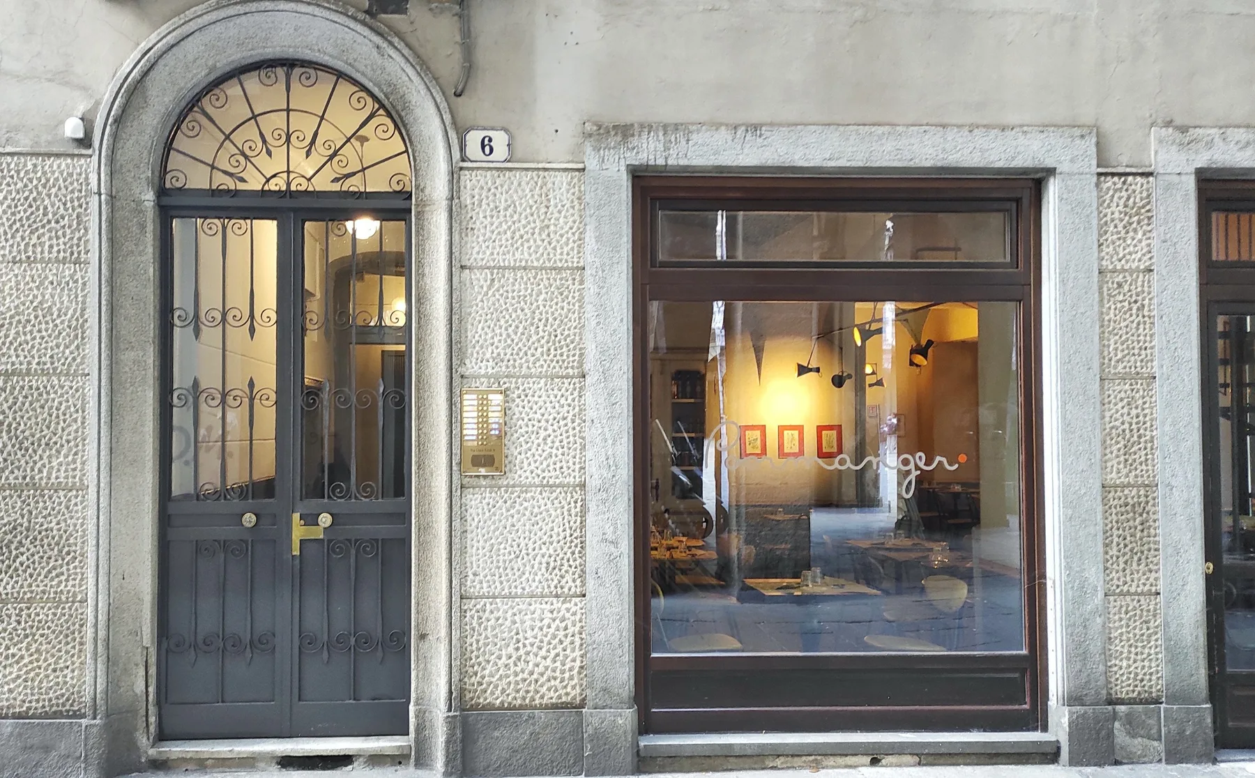 A street-facing storefront with a large display window and an arched entrance.