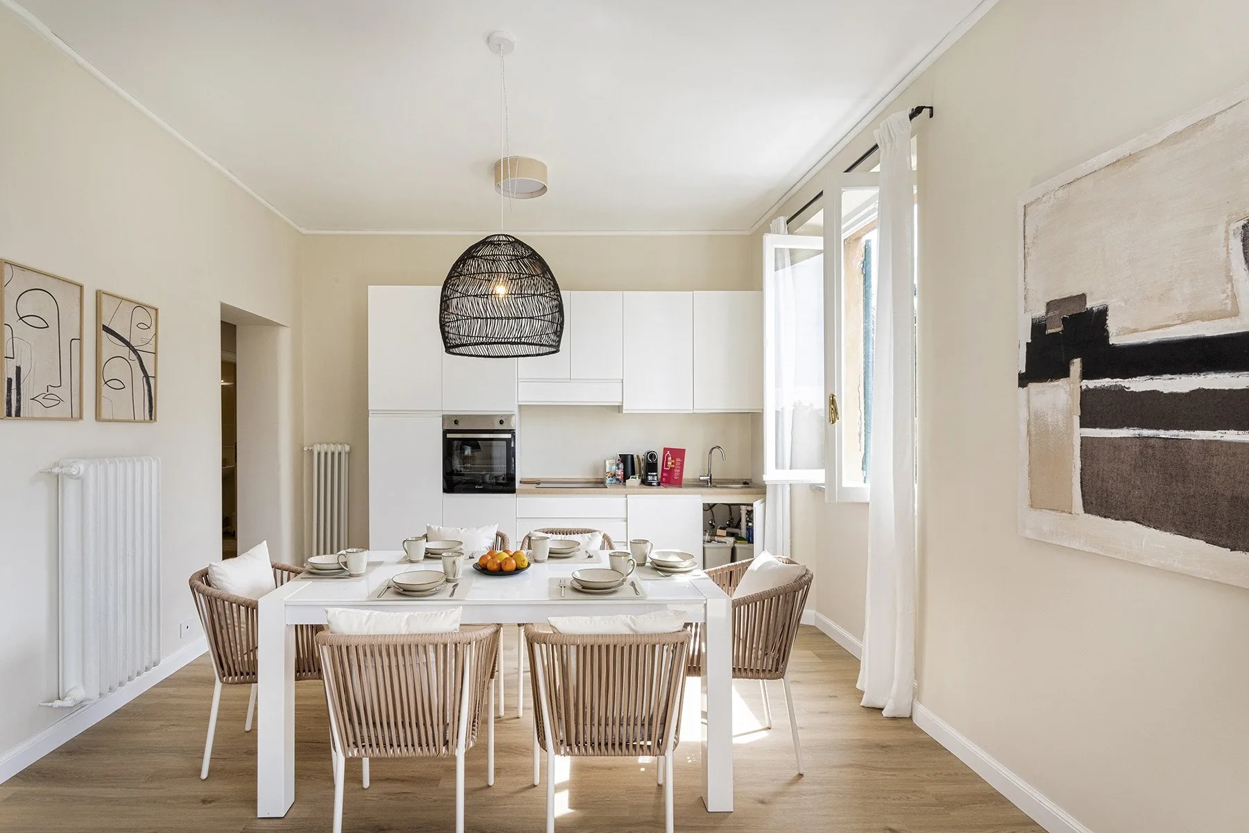 Dining area with a set table, pendant light, and kitchen cabinetry.
