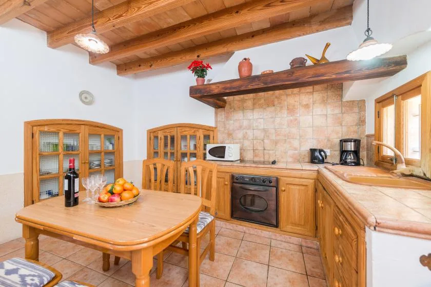 A warm-toned kitchen with wooden cabinets, a tiled backsplash, and a dining table.