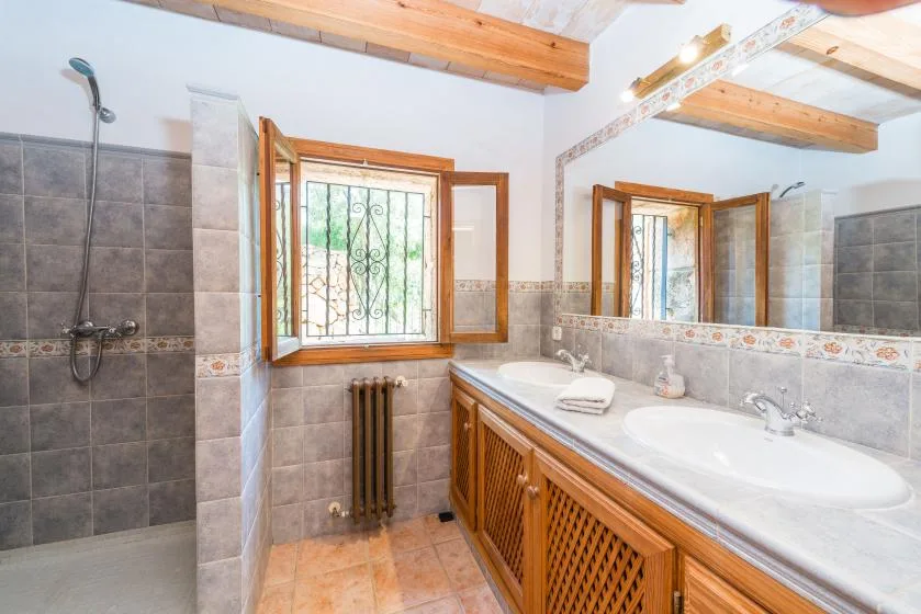 A bathroom with a long vanity, two sinks, and a large wall mirror.