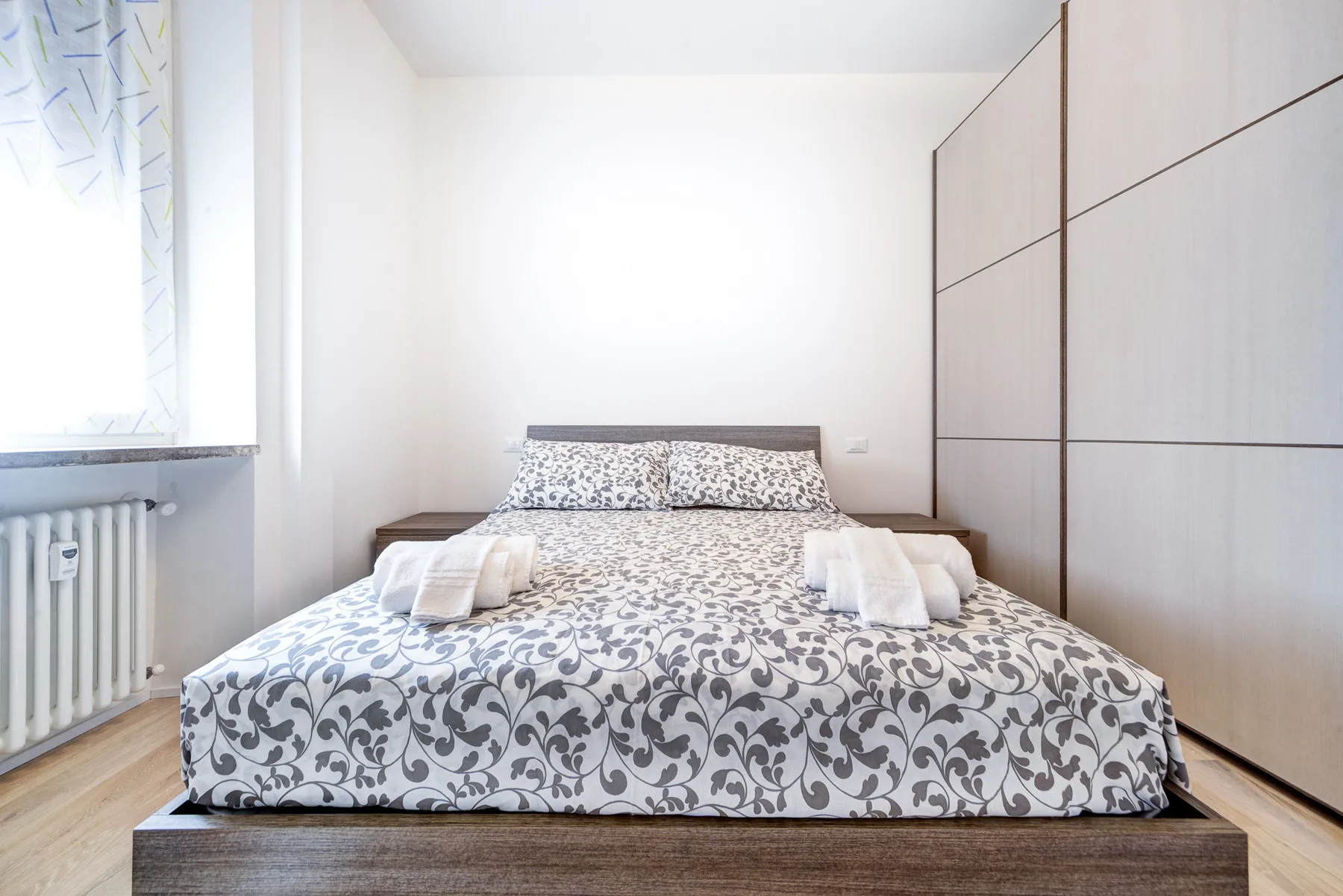 Un dormitorio con una cama estampada y un armario empotrado.