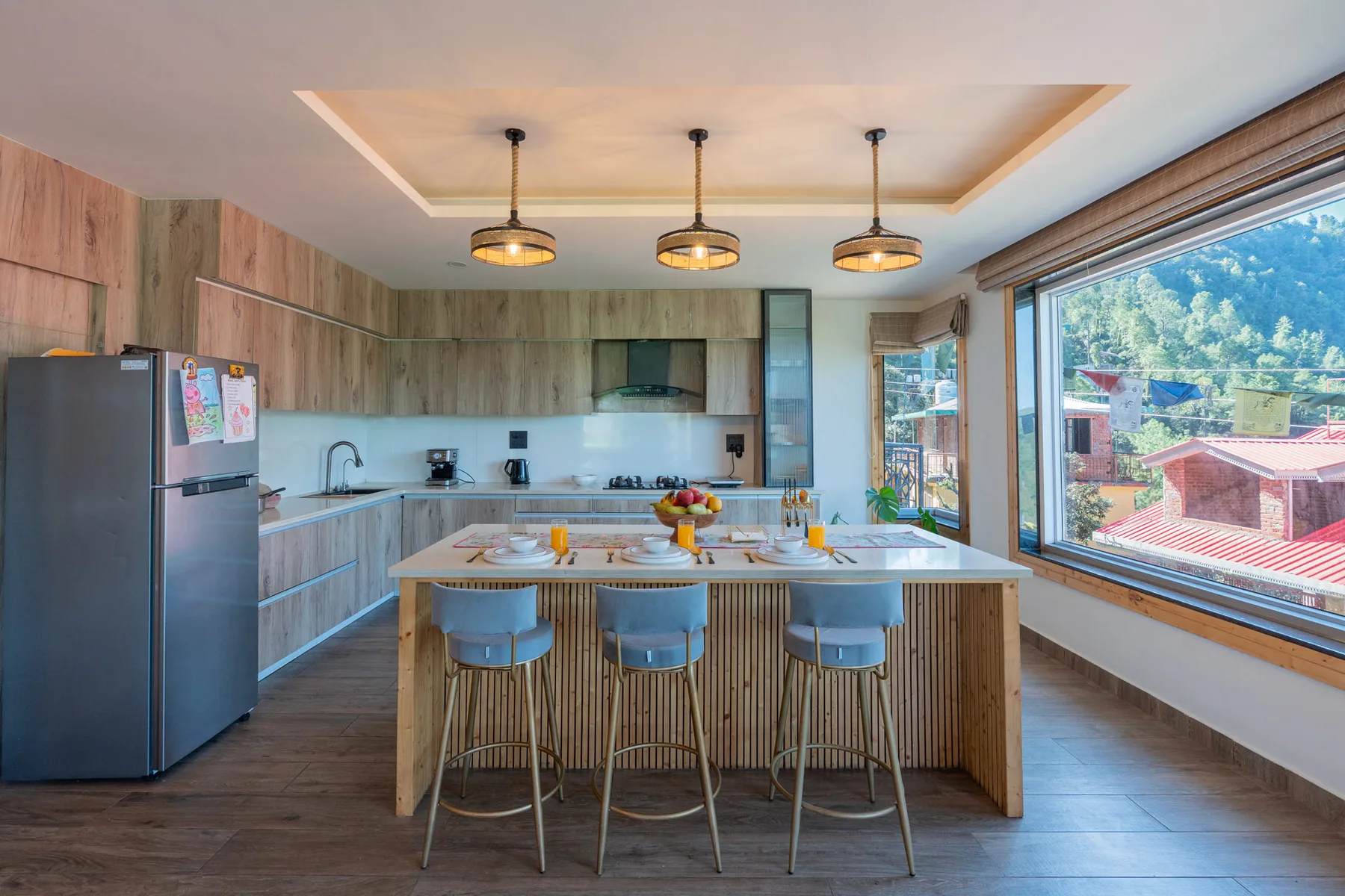 Una cocina luminosa con una isla central y grandes ventanas con vistas al exterior.