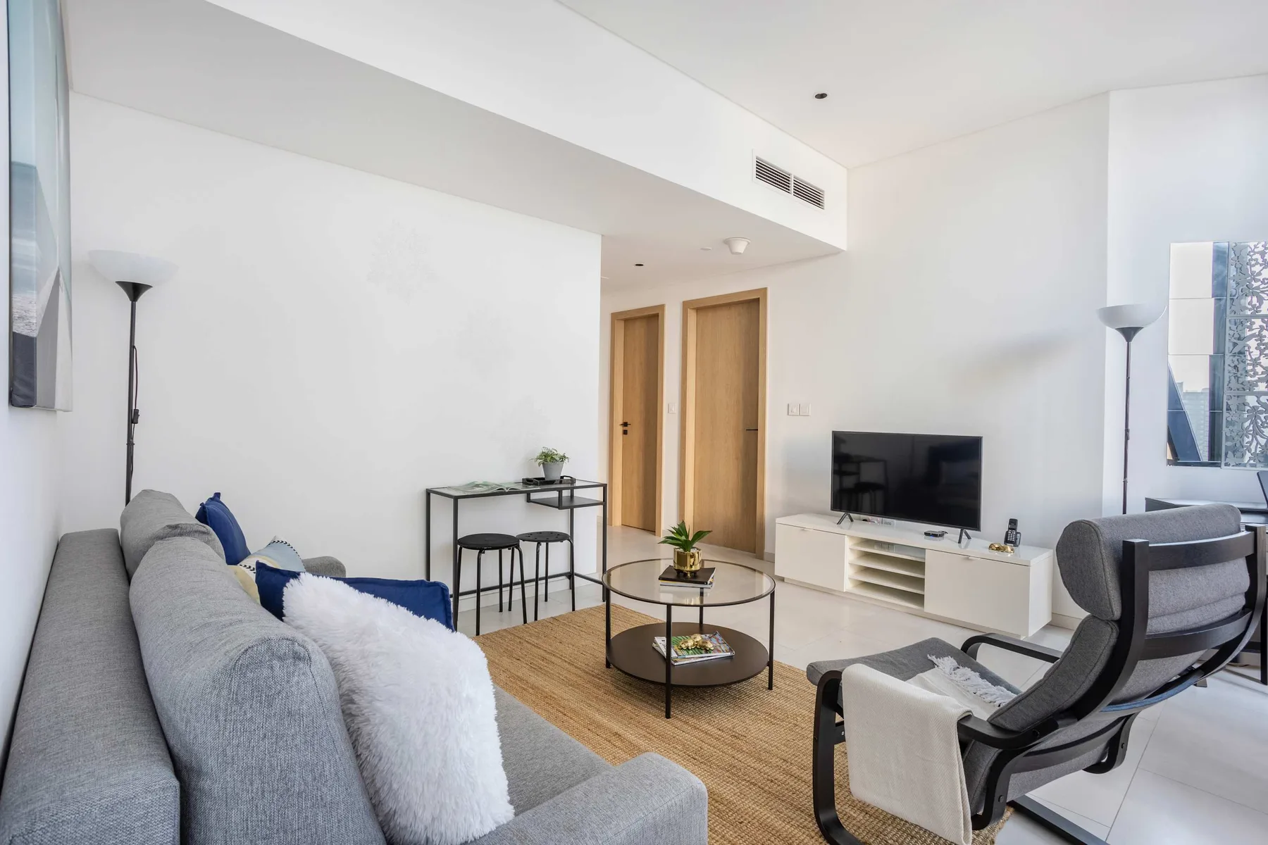 A bright living room with seating, a television, and a coffee table.