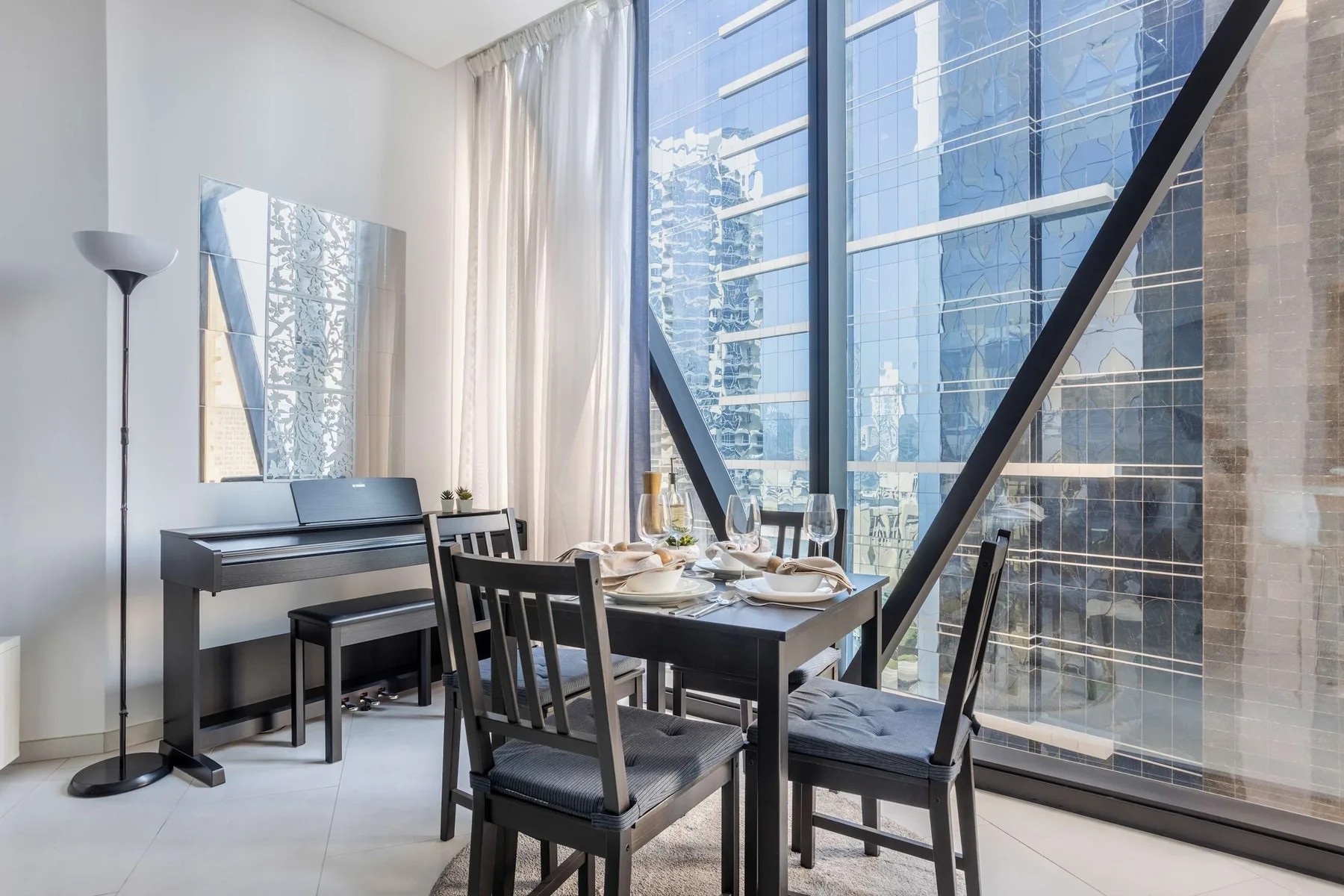 Un comedor con una mesa y sillas junto a grandes ventanas.