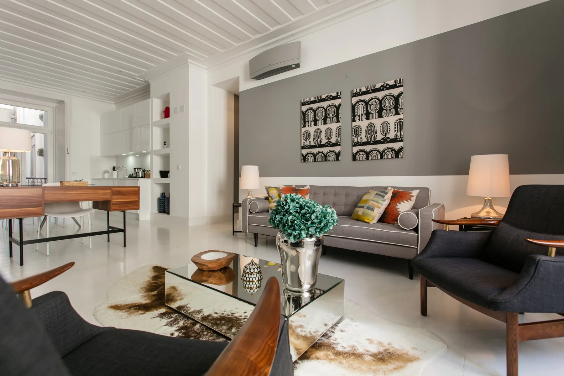 Living room with seating, a glass coffee table, and artwork on the wall.