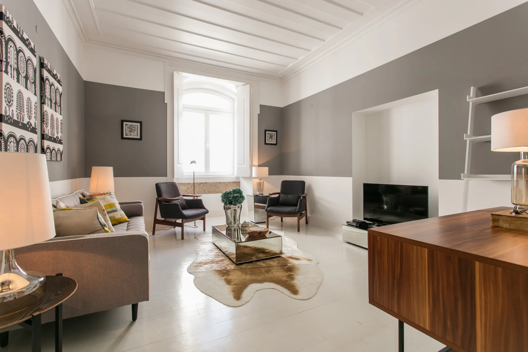 A living room with seating, a coffee table, and a television.