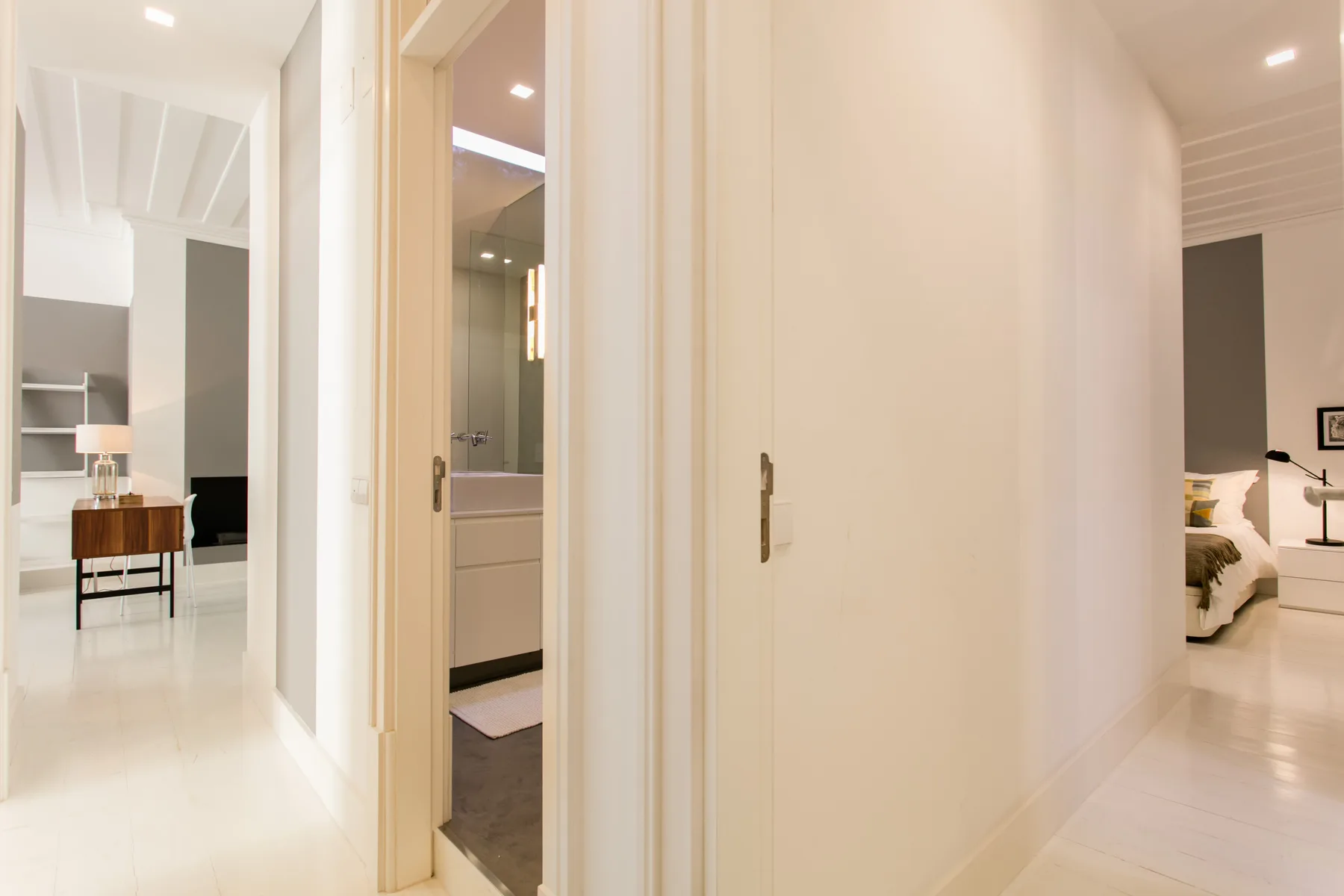 A bright interior hallway connects several open doorways.