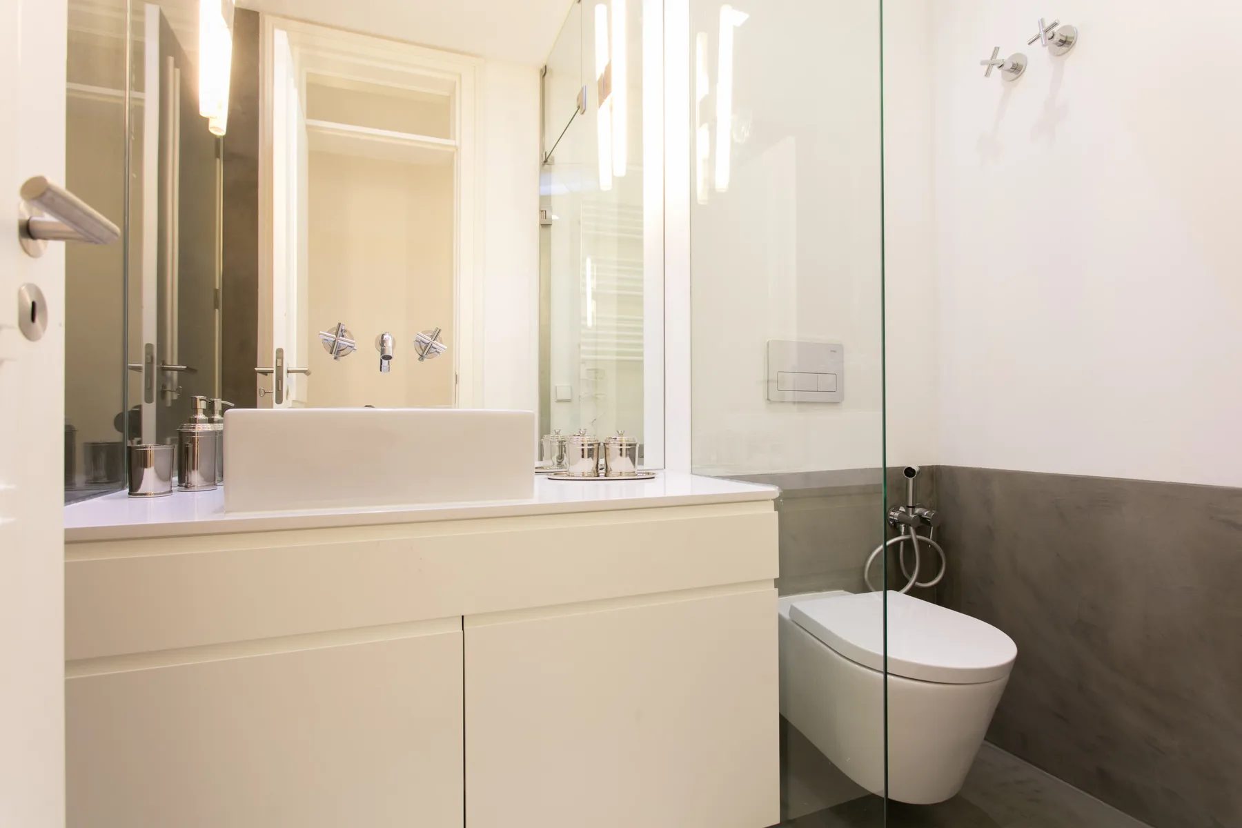 A bright bathroom with a basin, vanity, and glass shower.
