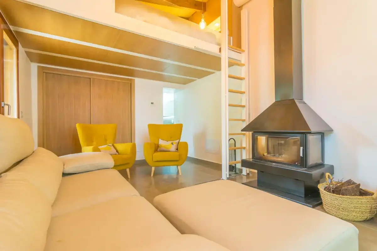 Living room with seating and a freestanding fireplace.