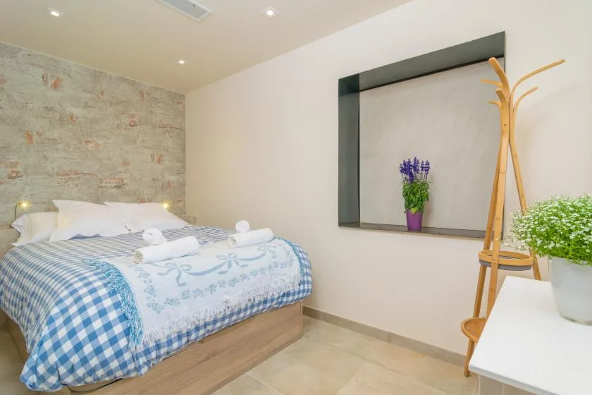 A bedroom with a bed dressed in blue-and-white patterned bedding.