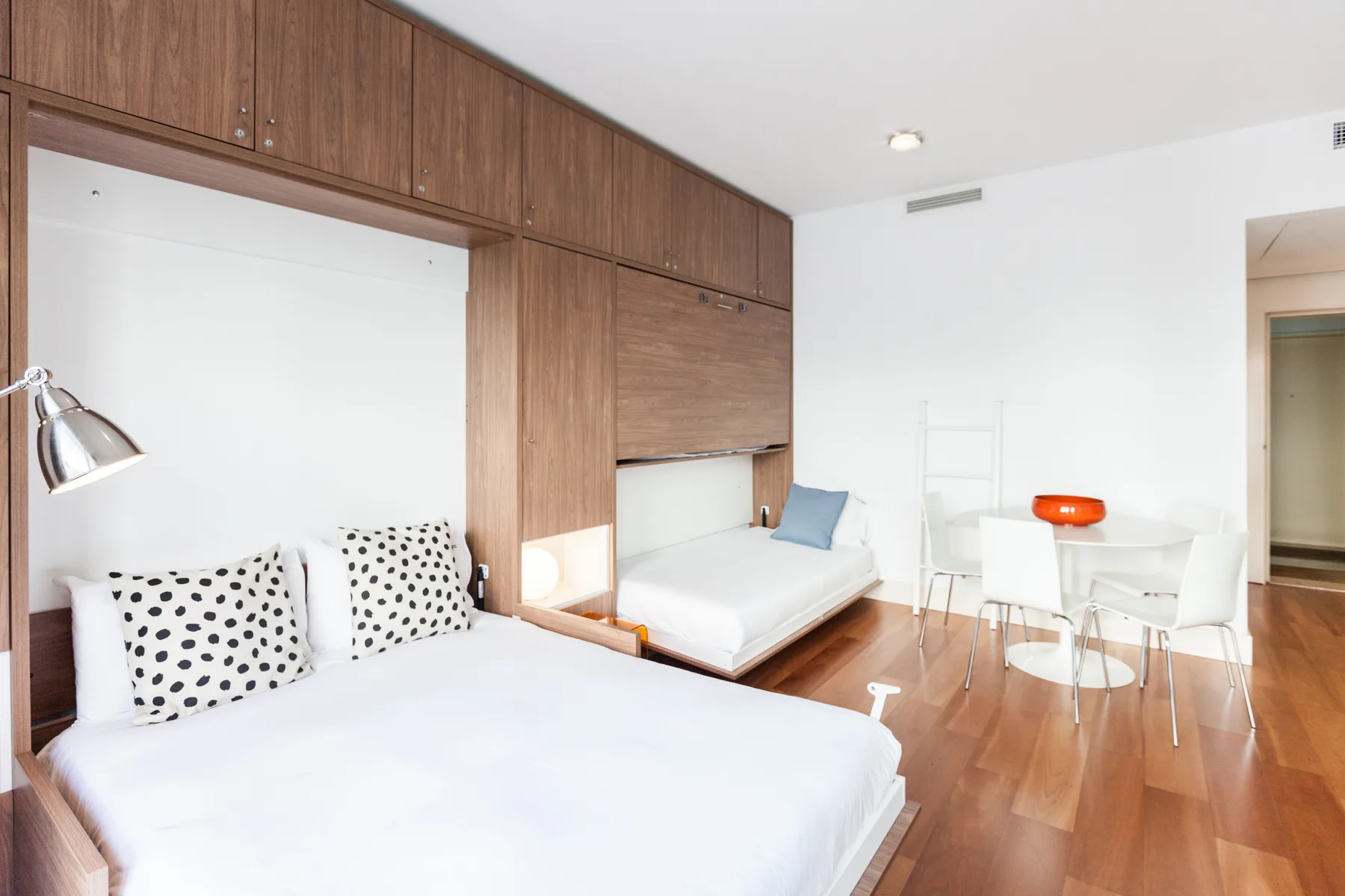 Un dormitorio con una cama grande, una cama pequeña y una zona de comedor.