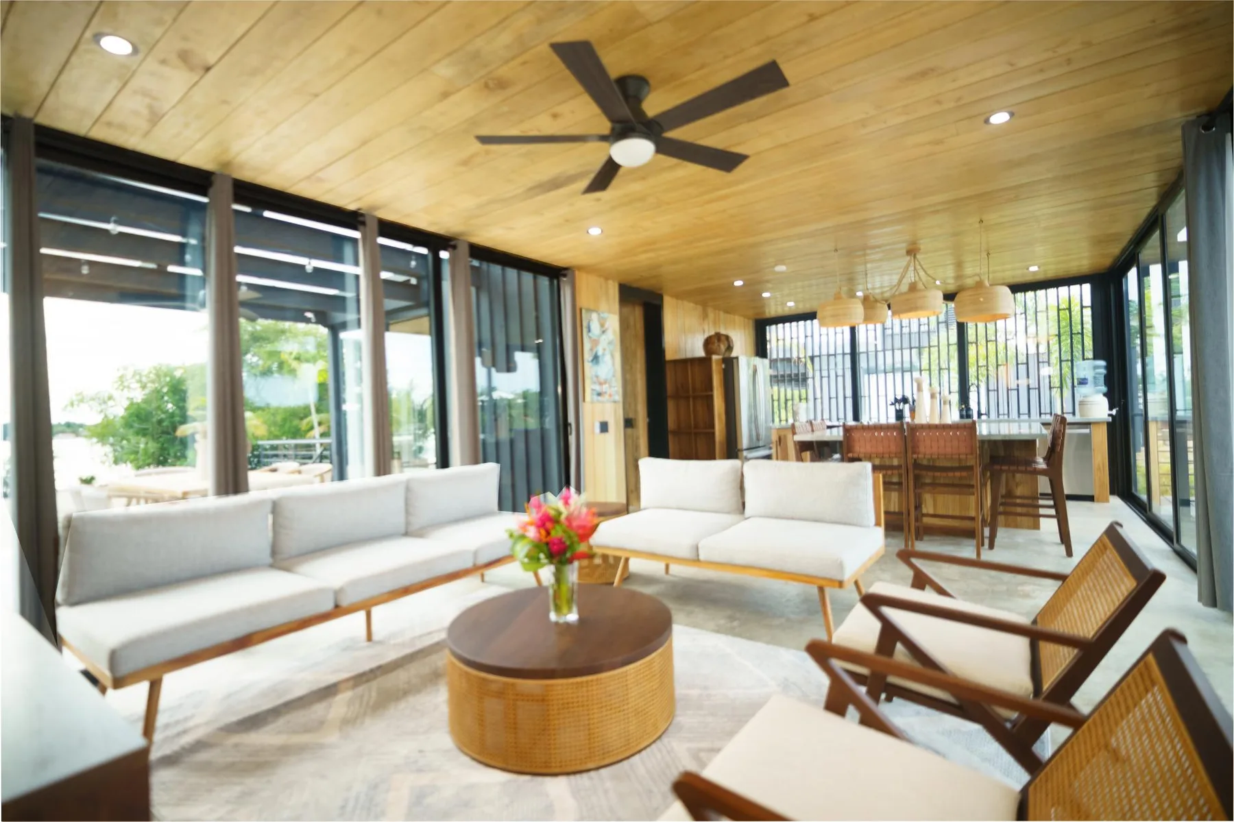A bright living and dining area with seating beside large windows.