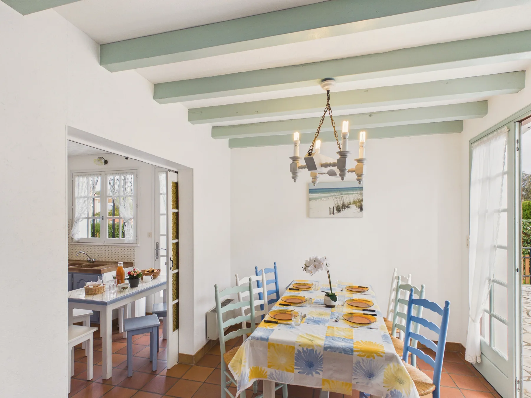A dining area with a long table set with plates and chairs.