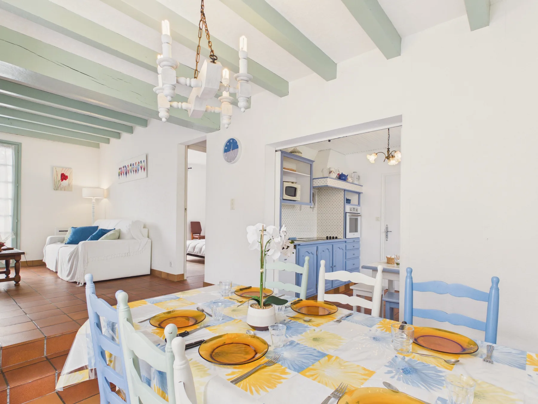 A bright dining area with a set table and blue-and-white seating.