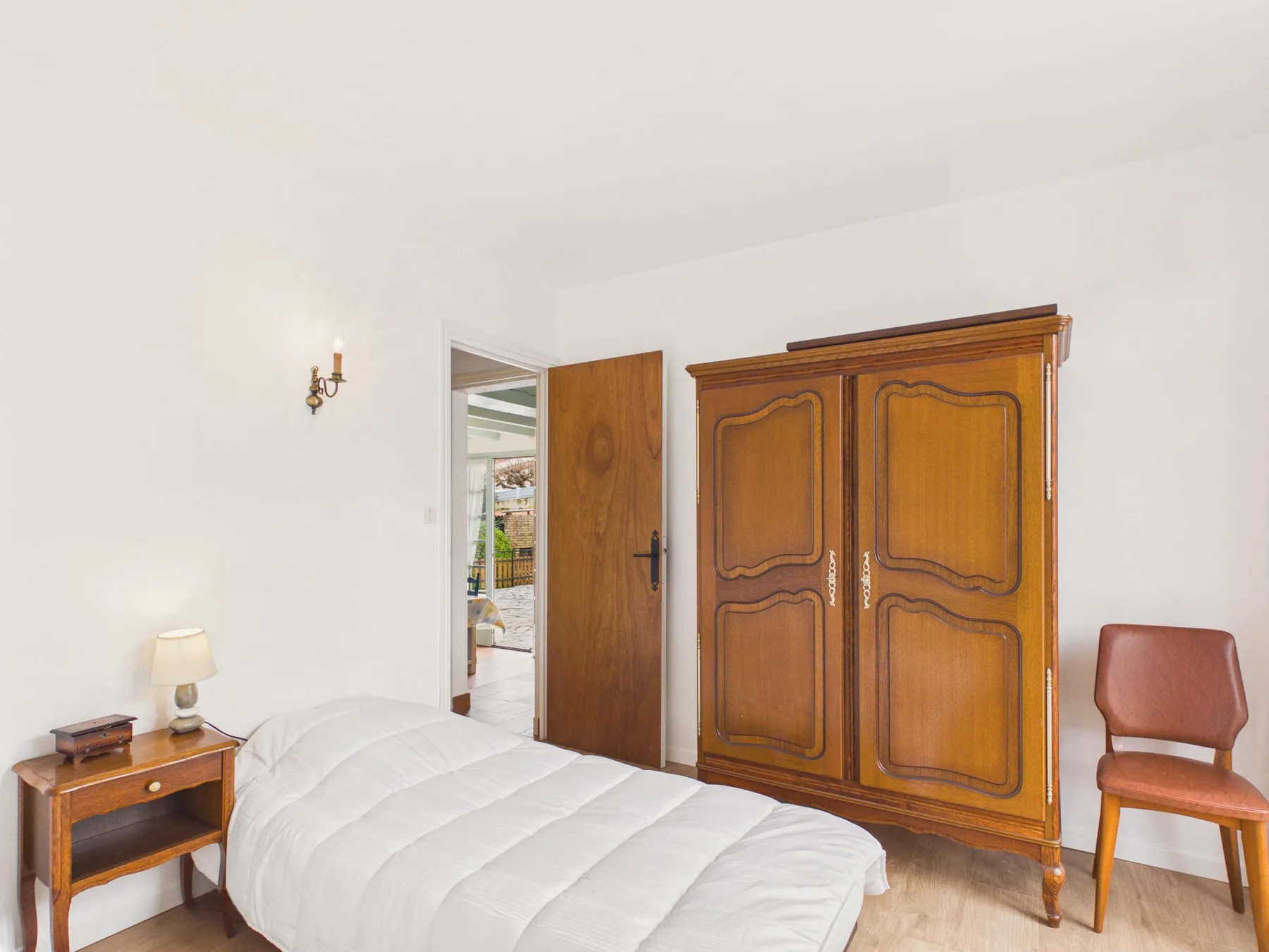 Bedroom with a bed and wooden wardrobe.