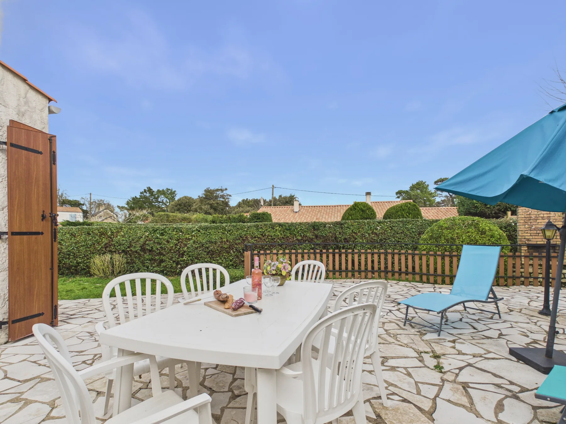 An outdoor patio with a white dining table and seating.
